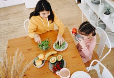 image of a mother and daughter eating nutritious food to stay healthy and improve their wellness