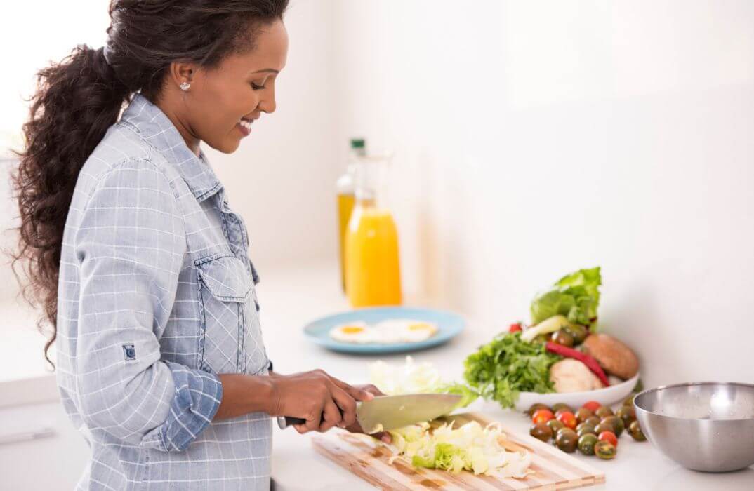 image of woman in kitchen preparing plant-based meal